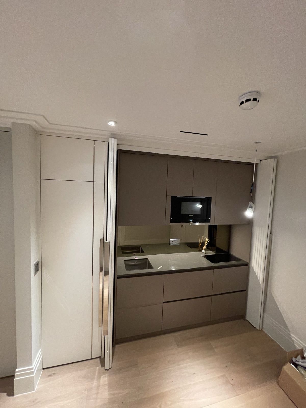 Concealed kitchenette with pocket doors - premium studio finish
